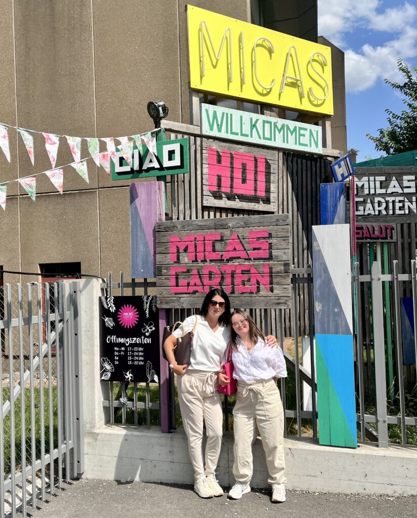 Zwei Frauen vor den Eingangs-Schildern von Micas Garten, einer Eventlocation in Zürich.
